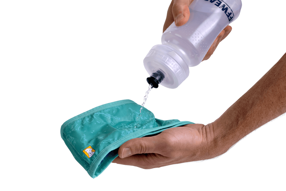 Person benutzt Swamp Cooler™ Halstuch mit Trinkflasche, während Wasser auf das turquoise Tuch fließt.
