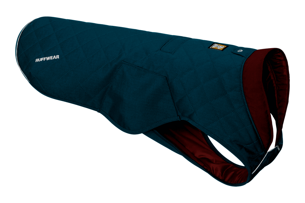 Blauer gesteppter Hundemantel von Ruffwear mit burgunderroter Fütterung und reflektierenden Elementen für sicheren Spaziergänge.
