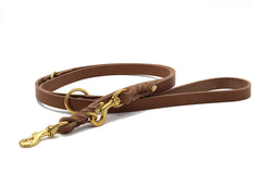 Braune Lederleine mit goldenen Beschlägen und Karabinerhaken, elegant und stabil, für einen stilvollen Hundespaziergang.