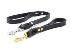 Schwarze Hundeleinen aus Leder mit silbernem und goldenem Karabinerhaken, verziert mit engem Knoten.