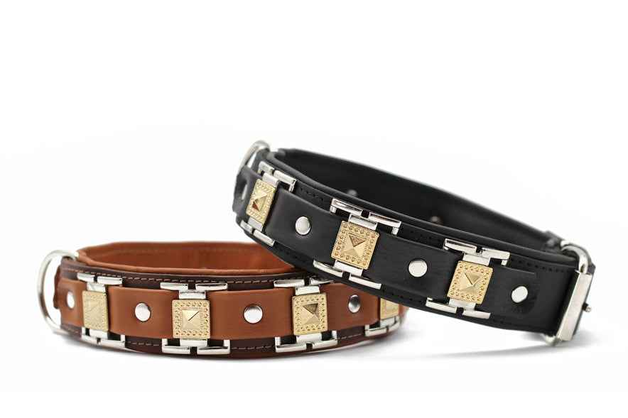 Braune und schwarze Hundehalsbänder mit metallischen Elementen und goldfarbenen Verzierungen im klassischen Design.
