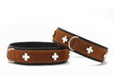 Braune Nubukleder-Hundehalsbänder mit silbernen Schweizer Kreuz-Symbolen und schwarzem Innenbesatz.