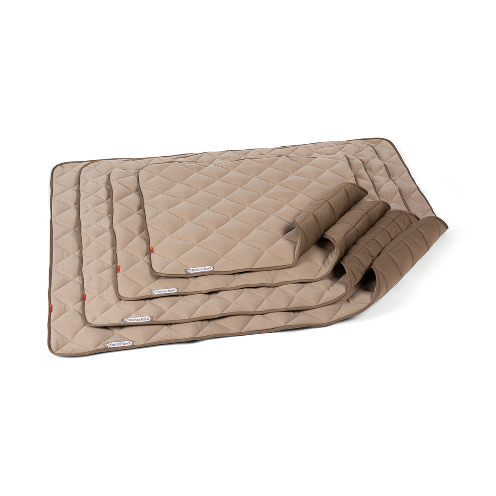 Beige Fleece Steppdecke in verschiedenen Größen mit kariertem Muster und Markenlabel. Ideal für Gemütlichkeit und Stil.