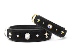 Exklusive schwarze Hundehalsbänder mit goldenen und silbernen Verzierungen sowie Schmucksteinen und Fleur-de-Lis-Motiven.
