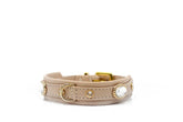 Elegantes hellbeiges Lederarmband mit goldfarbenen Elementen und glitzernden Steinen, klassische Schnalle.
