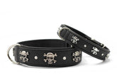 Schwarze Leder-Hundehalsbänder mit Totenkopf-Motiven und glänzenden Steinen, ausgestattet mit silbernen Schnallen.