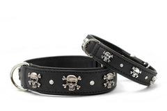 Schwarze Leder-Hundehalsbänder mit Totenkopf-Motiven und glänzenden Steinen, ausgestattet mit silbernen Schnallen.