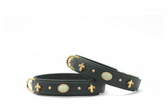 Zwei stilvolle Armbänder aus schwarzem Leder mit goldenen Verzierungen und ovalem Stein.