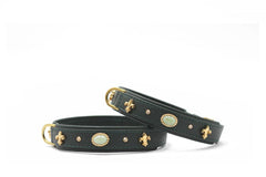 Zwei stilvolle Armbänder aus schwarzem Leder mit goldenen Verzierungen und ovalem Stein.