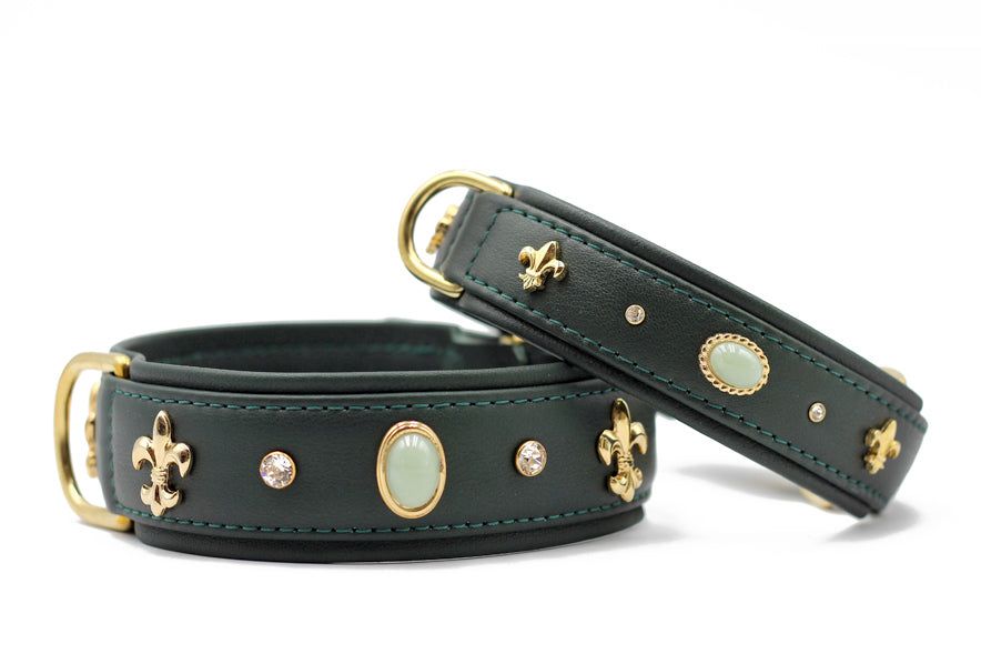 Elegante Hundehalsbänder aus dunklem Leder mit goldenen Verzierungen und grünen Steinen für stilvolle Haustiere.