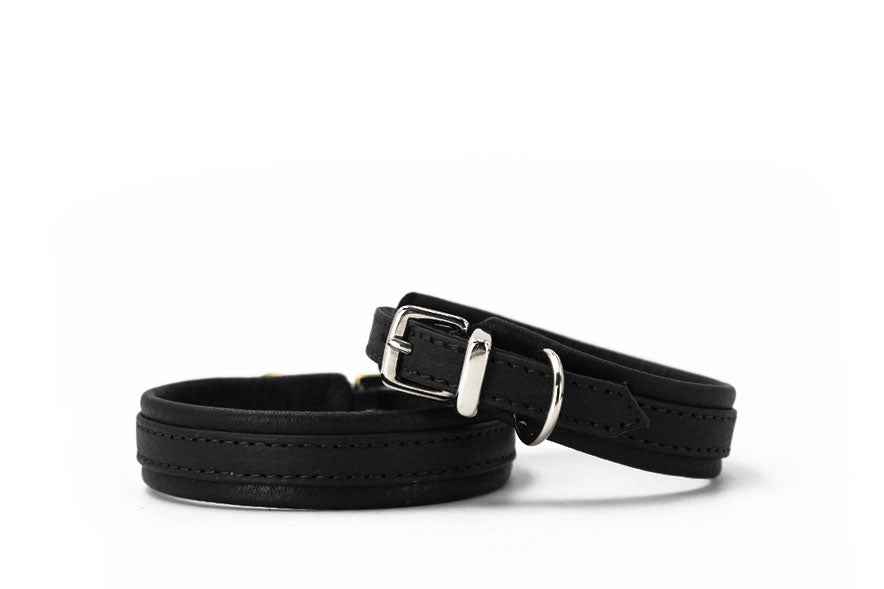 Zwei elegante schwarze Lederarmbänder: eines mit verstellbarer Schnalle, das andere in schlichter, glatter Ausführung.