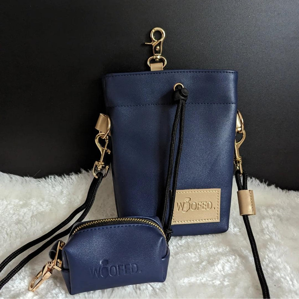 Dunkelblaue Handtasche aus Kunstleder mit goldfarbenen Details und passender Geldbörse im Bild.