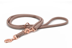 Beige Rundgenähte Lederleine für Hunde mit weicher Polsterung und roségoldenem Karabinerhaken. Ideal für stilvolle Spaziergänge.