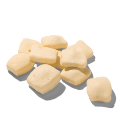"FRED Käsepops Rind: Kleine, helle, quaderförmige Snacks mit poröser Textur auf einer Fläche verteilt."