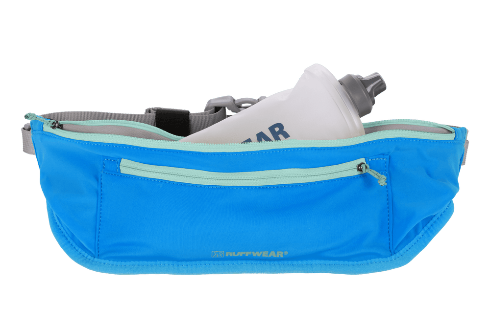 "Ruffwear Trail Runner Laufgürtel in Blau mit grauem verstellbarem Gurt und transparenter Wasserflasche für Hundebegleiter."