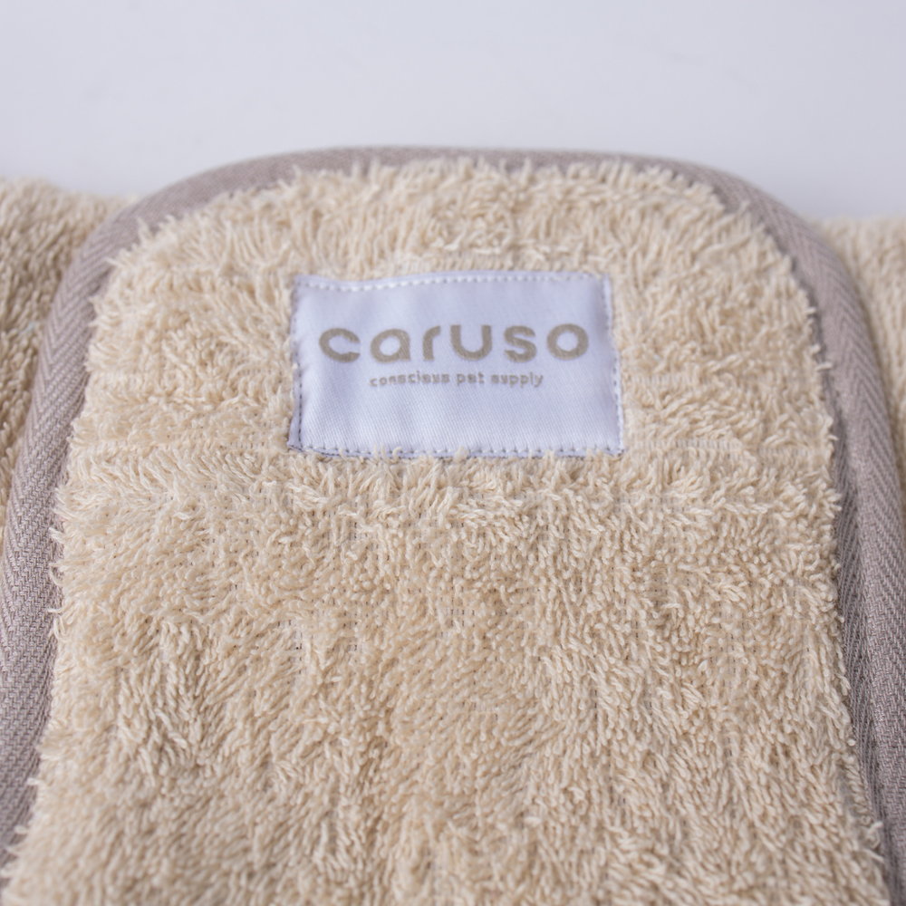 "Beige Hundebademantel Cozy Hug aus flauschigem Material mit Etikett 'caruso' und 'conscious pet supply'."