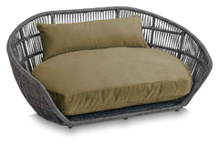 "Modernes PRADO Design-Hundebett OXFORD in grauer Rattanoptik mit weichem, olivgrünem Kissen für stilvolle Hunde."