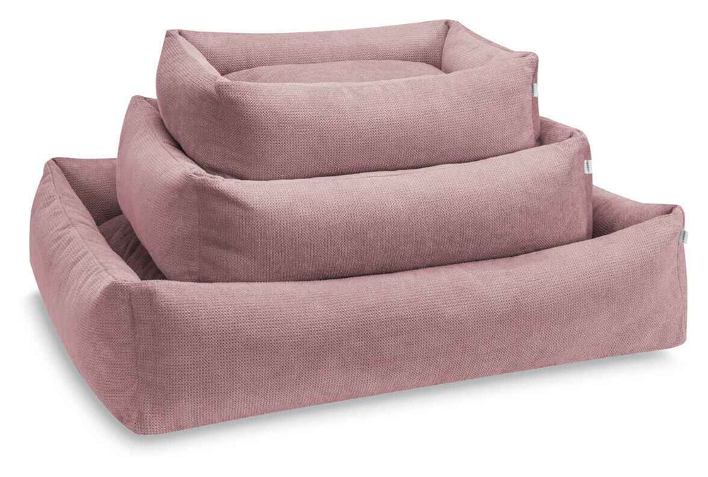 "Drei gestapelte rosa Hundebetten in quadratischer Form mit hohen Seiten und gepolsterter Innenseite."