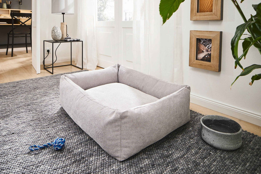 "CLASSIC Hundebett TUDOR in modernem Wohnraum, rechteckig mit gepolsterten Seiten, ideal für gemütliches Liegen."