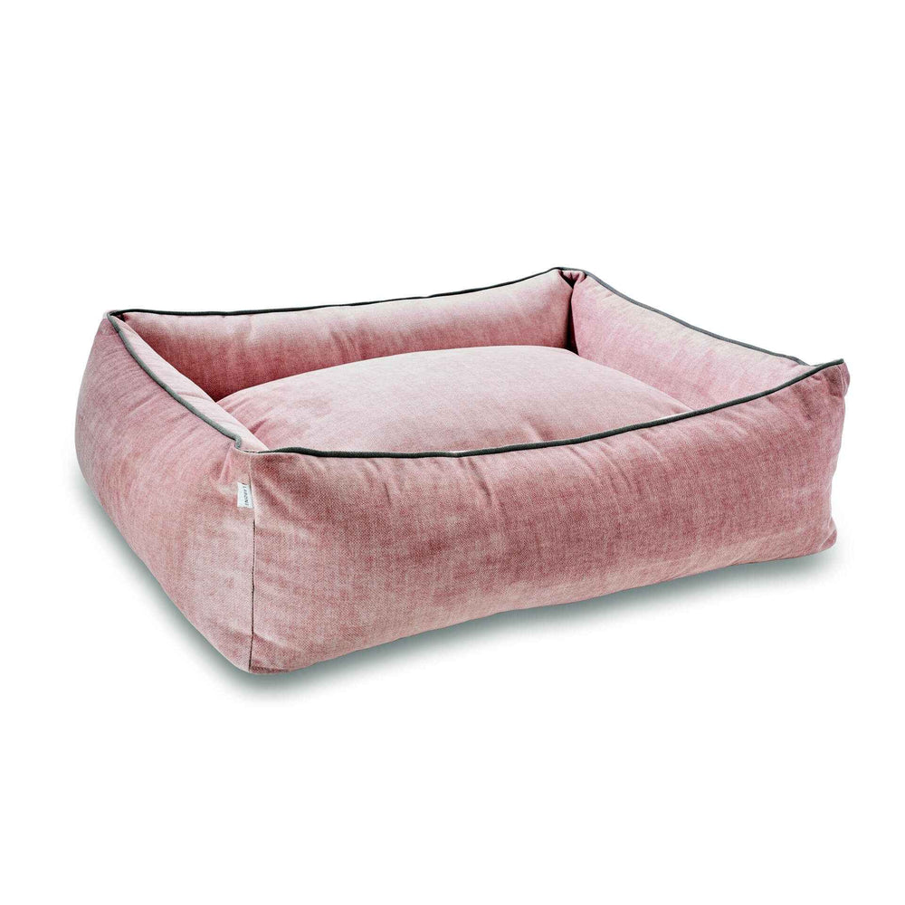 "Quadratisches Hundebett in sanftem Rosa mit gepolstertem Innenbereich und schlichter, textilartiger Optik."