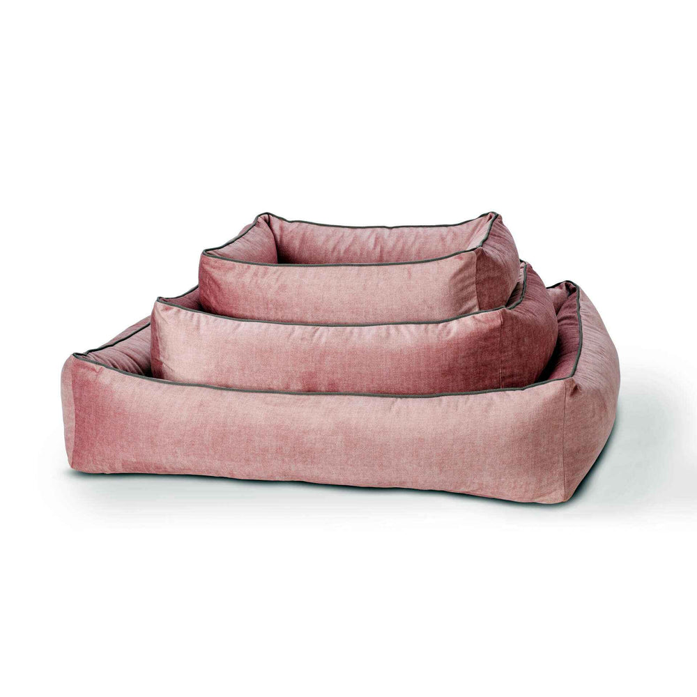 CLASSIC Hundebett GLAM in rosa, samtig, gestapelt in verschiedenen Größen auf weißem Hintergrund. Gepolsterte Kante für Komfort.