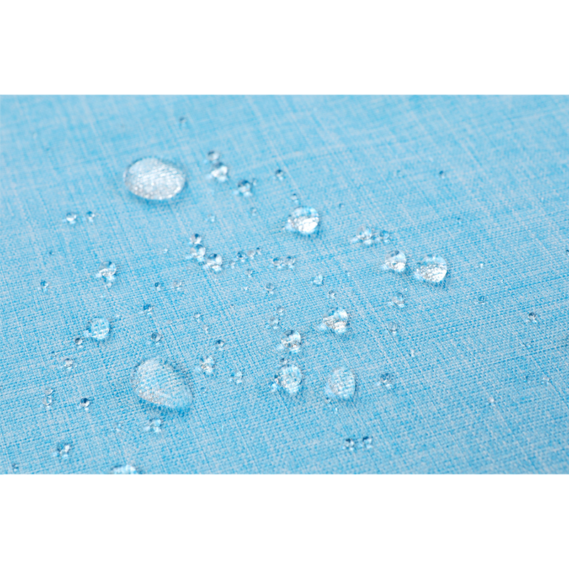 Hellblaue wasserabweisende Stoffoberfläche mit klaren Wassertropfen, die das Licht reflektieren.