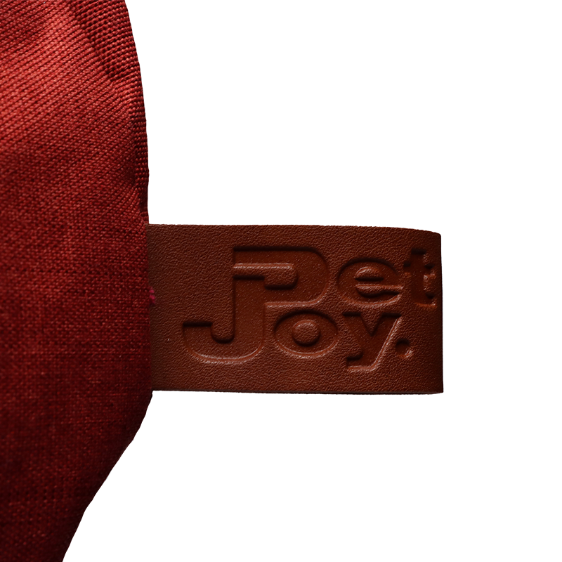 "Rotes Doggy Bagg Strong Produkt mit braunem Etikett und reliefartiger 'PetJoy' Schrift."