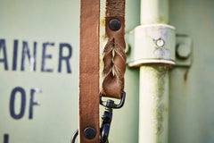 ALT-Text: Klassische braune Lederleine mit spezieller Flechtung und schwarzem Karabinerhaken für vielseitige Einsätze.