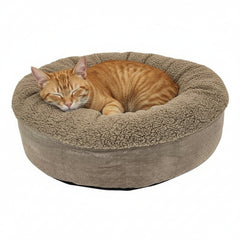 Rundes Katzenbett "TEDDY" in Beige mit flauschigem Rand, ideal für eine schlafende orangefarbene Katze.
