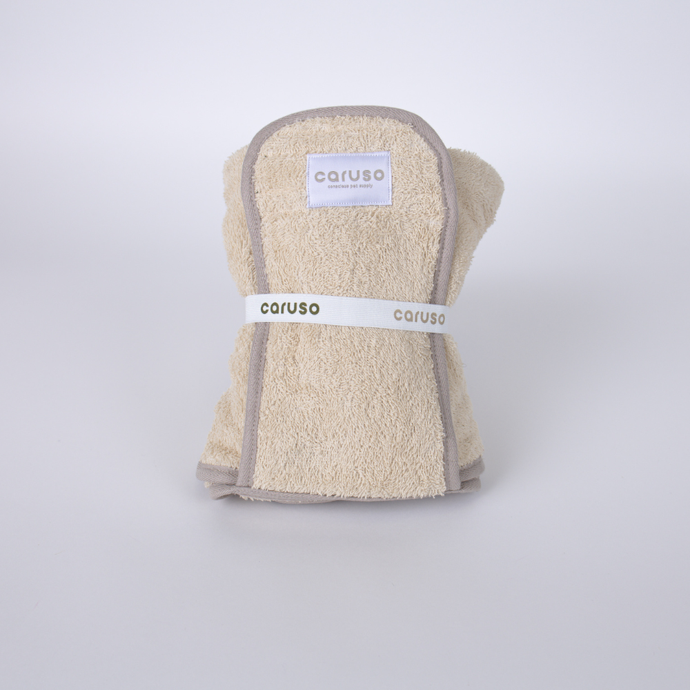Faltbarer Hundebademantel Cozy Hug in neutralen Farben mit "caruso" Aufnäher, ideal für nasse Hunde.