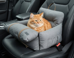 Grauer Autositzschutz für Haustiere mit einer orangefarbenen Katze auf dem Beifahrersitz. Gepolstert und sicher.