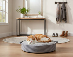 Gemütliches runden Katzenbett "Nola" mit orange-weißer Katze auf Holzboden in stilvollem Wohnambiente.