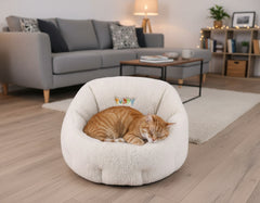 Gemütlicher ovaler Katzenkorb "Puppy" mit schlafender orangefarbener Katze in modernem Wohnzimmer.
