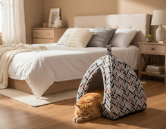 Gemütlicher Raum mit Bett, Holz-Nachttisch und Katzenspielhaus im zeltähnlichen Design.