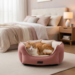 Gemütliches ovales Katzenbett Majid in rosa mit schlafender orangefarbener Katze im stilvollen Schlafzimmer.