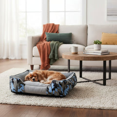 Ein Hund entspannt in einem gepolsterten komfortablen Kissenbett im stilvollen Wohnzimmer.