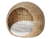 Rundes Katzenbett in Form einer Höhle aus geflochtenem Weidenmaterial mit weichem, weißem Innenfutter.