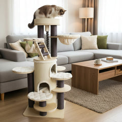 Beiger Kratzbaum CRIO mit mehreren Plattformen und einer sitzenden Katze im Wohnzimmer neben einem grauen Sofa.