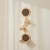 Moderner Wandhaken aus Holz in geschwungener Form mit drei runden Komponenten und hölzernen Stäben zur stabilen Befestigung.