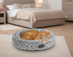 Gemütliches Katzenbett in Korbform mit schlafender orangefarbener Katze im Schlafzimmer.