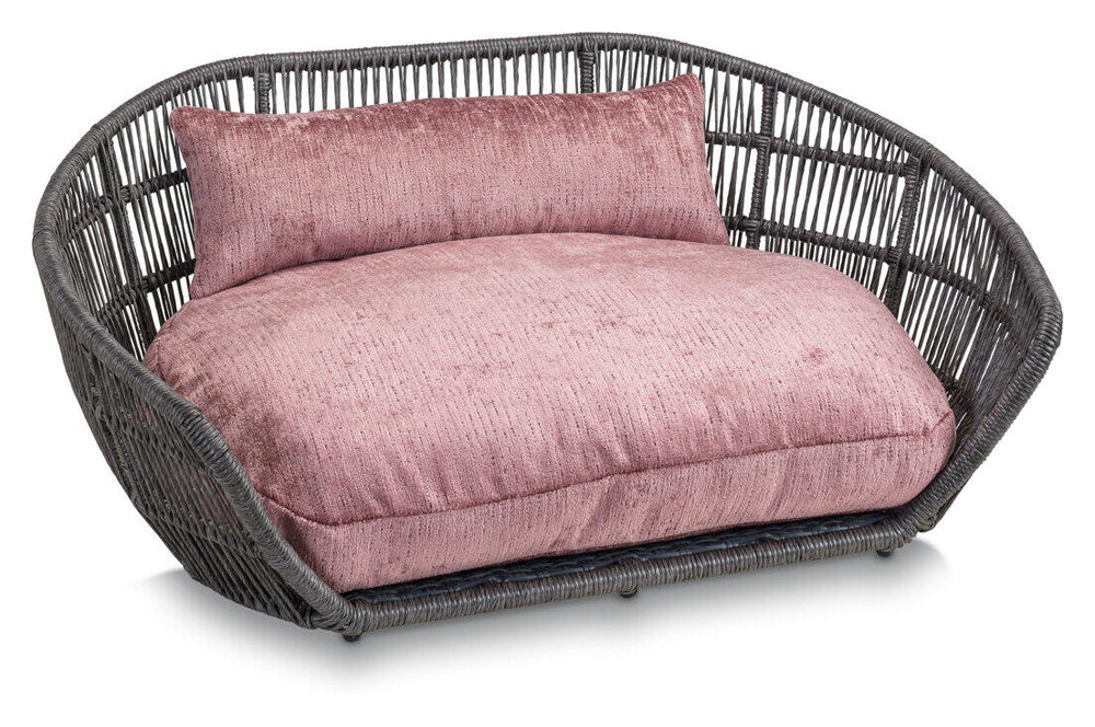Modernes ovales Hundebett ALLURE mit geflochtenem grauem Material und rosa gepolstertem Kissen für optimalen Komfort.
