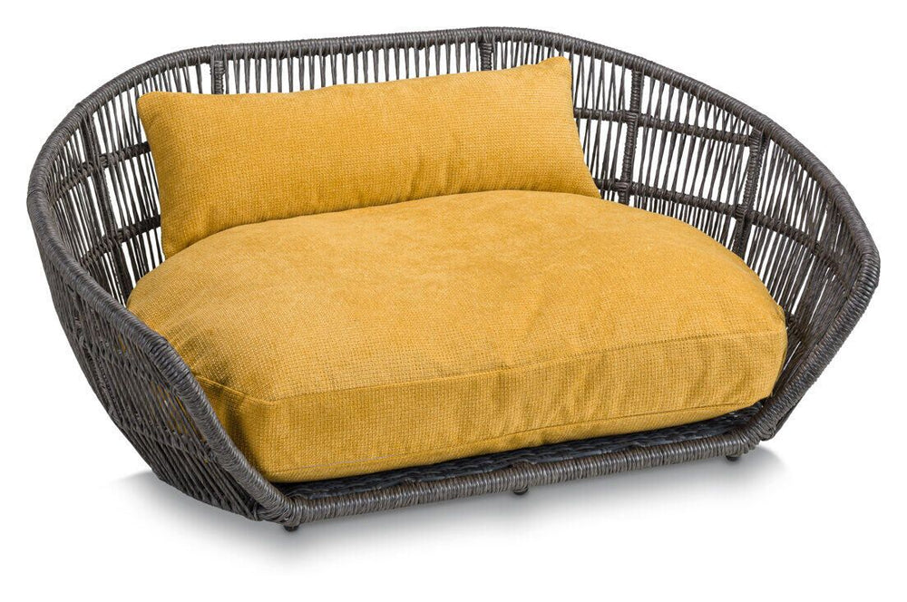 Modernes Hundebett TUDOR in ovaler Form mit geflochtenem grauen Rahmen und gemütlichem gelben Kissen.