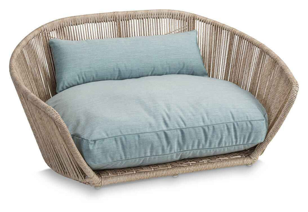 Modernes runder Schaukelstuhl aus geflochtenem Rattan mit hellblauem Kissen für gemütliches Wohnen.