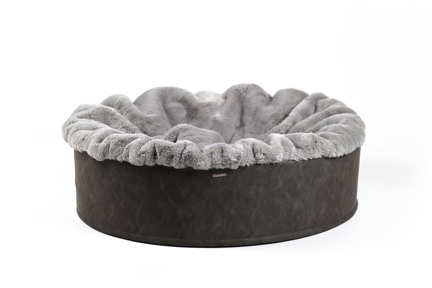 Rundes Hundebett mit grauem Innenfutter und dunklem Außenrand, ideal zum Kuscheln für Haustiere.