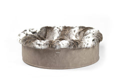 Bequemes, rundes Hundebett Buddelnest® in Grau mit fellähnlicher Verzierung in Braun und Weiß. Ideal für entspannte Hundemomente.