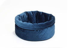 Rundes Hundebett in dunklem Blau mit gestepptem Design und hohem Rand für optimalen Schlafkomfort.