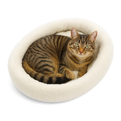 Getigerte Katze entspannt in einem ovalen, weichen Kuschelbett mit flauschiger Oberfläche. Komfort für jeden Katzenliebhaber.