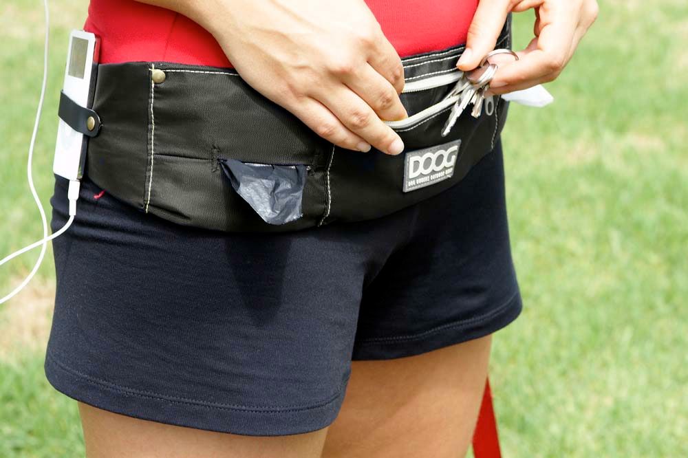 Person trägt schwarzen DOOG Gürteltasche im Sportstil, ideal für Schlüssel und Smartphone.