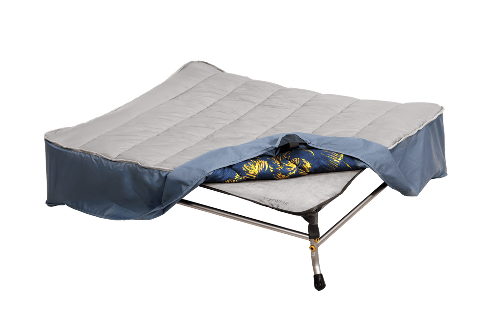 "Mt. EverRest™ Hundebett Bezug auf einer Campingliege mit grauer Matratze und buntem Schlafsack im Freien."