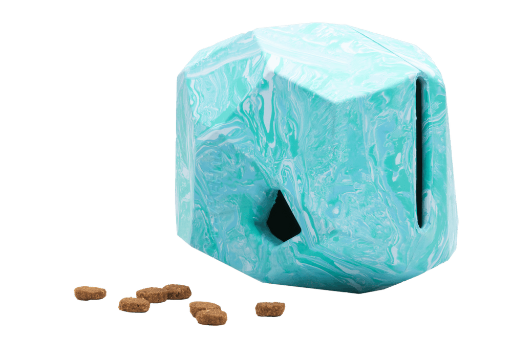 Skulpturaler Nag-a-Rock™ Futterspender in türkis-weißer Marmorierung mit geometrischer Form und Futteröffnung.